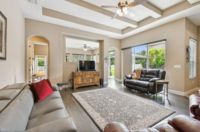 living room featuring a healthy amount of sunlight, ceiling fan, and dark wood-type flooring