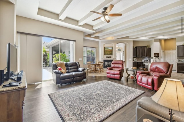 living room with beamed ceiling, hardwood / wood-style floors, sink, and ceiling fan