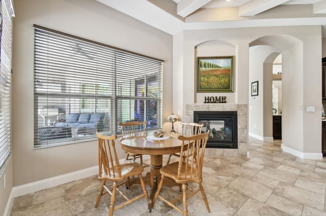 dining area featuring beamed ceiling and a fireplace