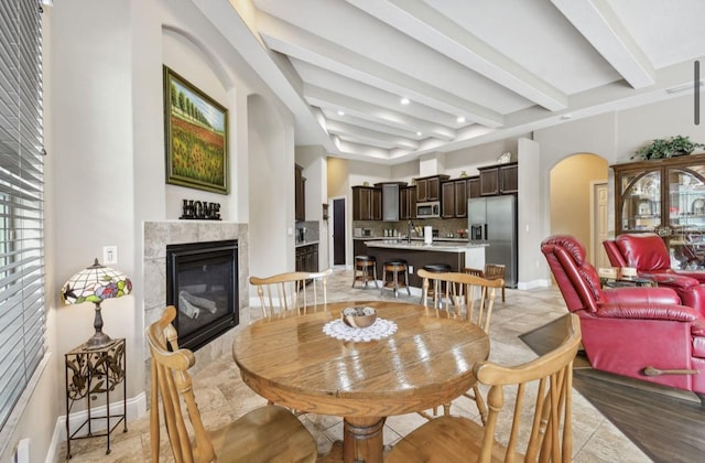 dining area featuring a fireplace and beam ceiling