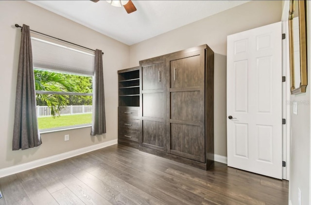 unfurnished bedroom featuring dark hardwood / wood-style flooring, ceiling fan, and a closet