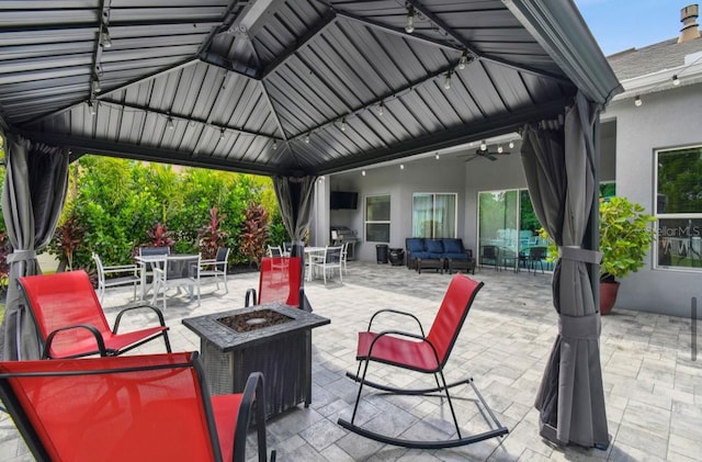 view of patio / terrace with a fire pit, ceiling fan, and a gazebo