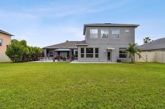 rear view of house with a lawn, a patio area, and a gazebo