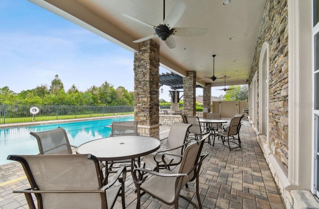 view of patio with ceiling fan and a fenced in pool