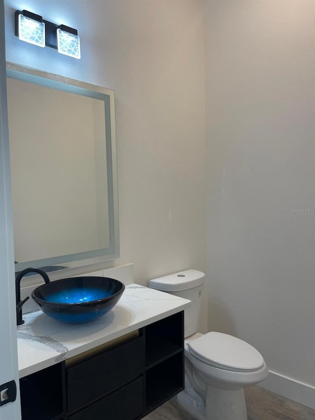 bathroom featuring vanity, wood-type flooring, and toilet