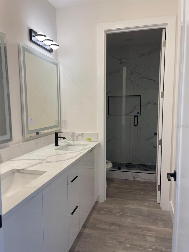 bathroom with walk in shower, vanity, wood-type flooring, and toilet