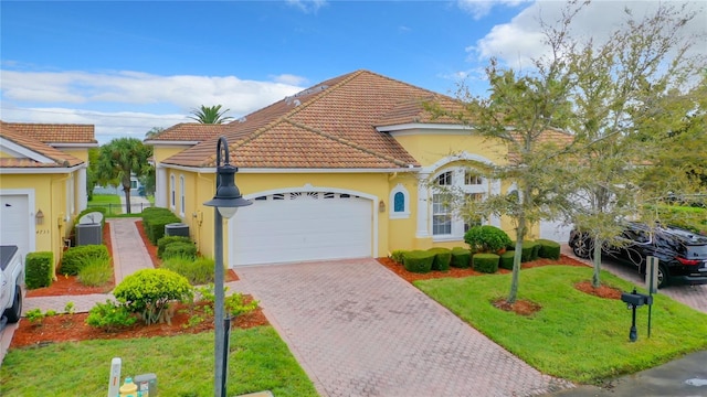 mediterranean / spanish-style home with a garage and a front yard