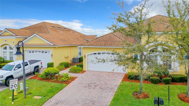 view of front of house featuring cooling unit, a front yard, and a garage