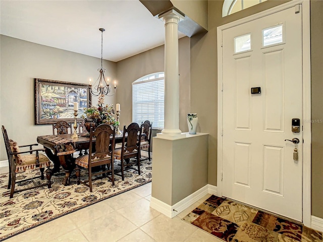 tiled entryway with a chandelier and decorative columns