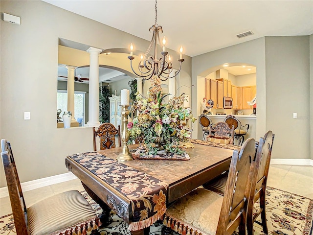 dining area with an inviting chandelier, light tile patterned flooring, and ornate columns