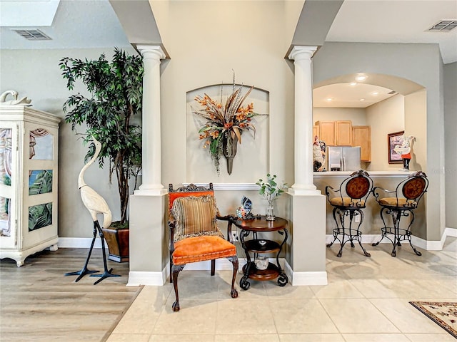 sitting room featuring light hardwood / wood-style flooring and ornate columns