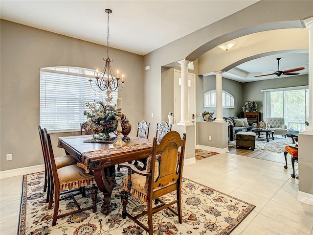 dining space with ceiling fan with notable chandelier, light tile patterned floors, and decorative columns