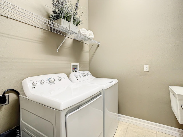 4737 Casswell Dr, New Port Richey, FL 34652 - laundry room with washing machine and clothes dryer, light tile patterned flooring, and baseboards