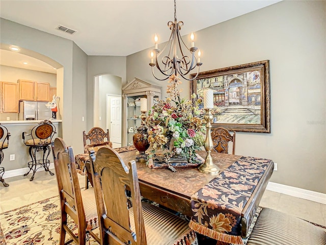 4737 Casswell Dr, New Port Richey, FL 34652 - dining space featuring arched walkways, a chandelier, baseboards, and light tile patterned floors
