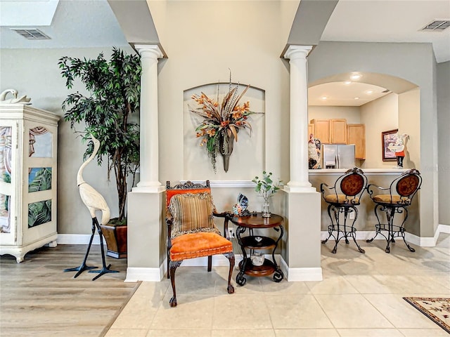 4737 Casswell Dr, New Port Richey, FL 34652 - living area featuring decorative columns, arched walkways, baseboards, and light tile patterned floors