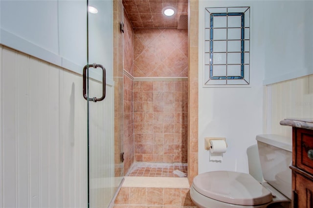 bathroom featuring toilet, a stall shower, and vanity