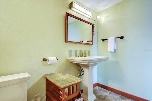 bathroom with toilet and baseboards