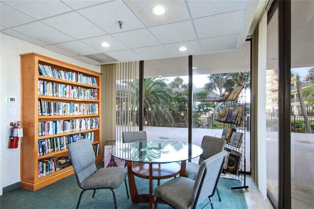 carpeted dining space with floor to ceiling windows, a drop ceiling, and recessed lighting