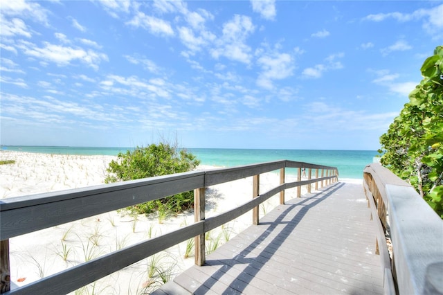 dock area featuring a water view and a beach view