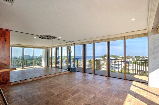 interior space featuring a wall of windows, a water view, visible vents, and recessed lighting