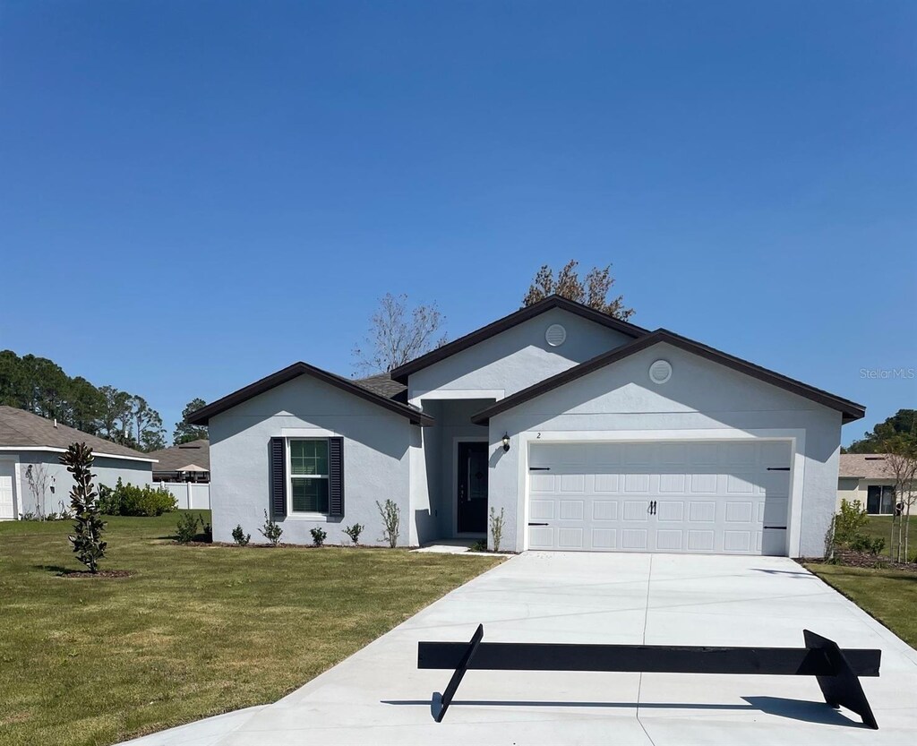 ranch-style home featuring a front yard and a garage