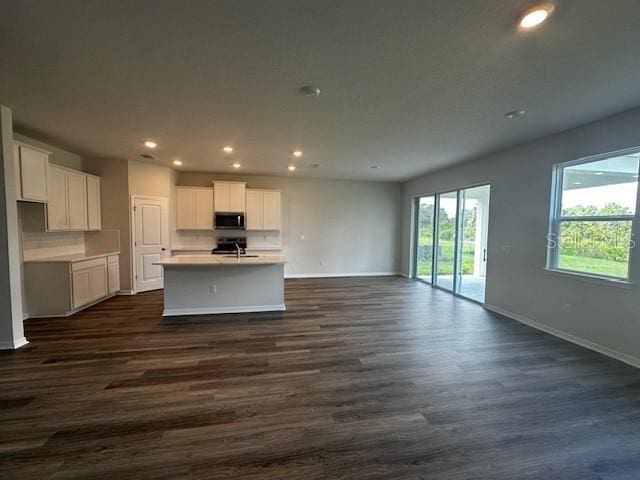 708 160th Ln E, Bradenton, FL 34212 - kitchen with stainless steel microwave, open floor plan, dark wood-type flooring, and recessed lighting