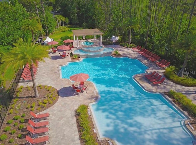 view of swimming pool with a community hot tub and a patio area