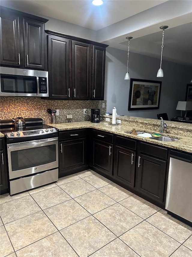 kitchen featuring pendant lighting, stainless steel appliances, backsplash, and sink