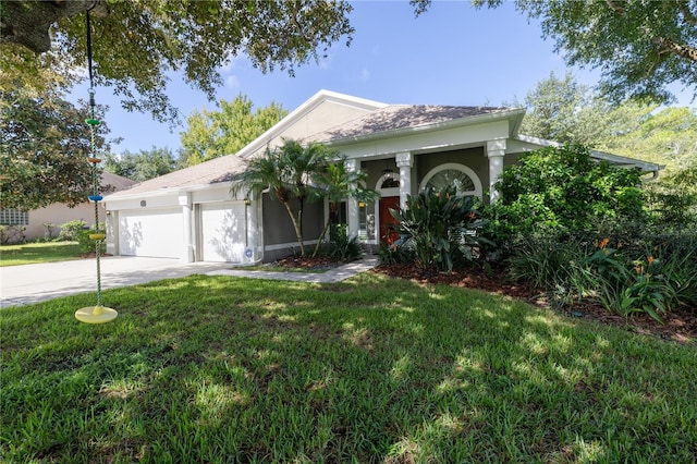 view of front facade featuring a garage, driveway, a front yard, and stucco siding