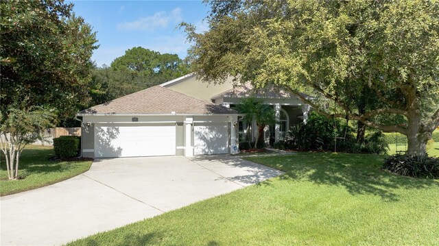 view of front of house with roof with shingles, stucco siding, a front lawn, concrete driveway, and a garage