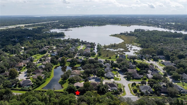 drone / aerial view with a forest view, a water view, and a residential view