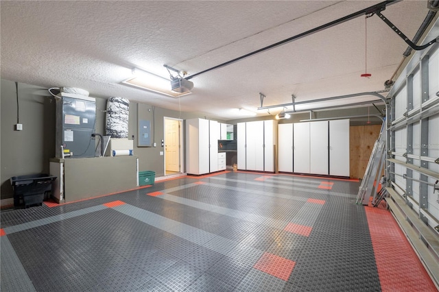 garage featuring electric panel, heating unit, and a garage door opener