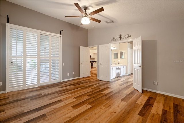 unfurnished bedroom with visible vents, baseboards, light wood-type flooring, ensuite bath, and a ceiling fan