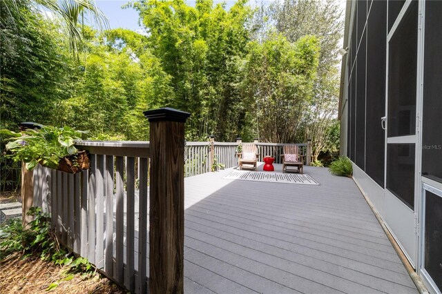 wooden deck with a sunroom