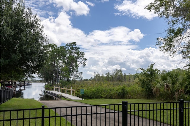 exterior space with a yard, a water view, and fence