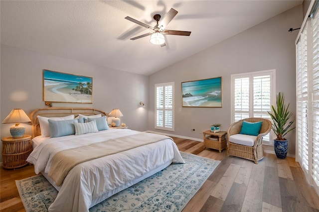 bedroom with lofted ceiling, wood finished floors, baseboards, and ceiling fan