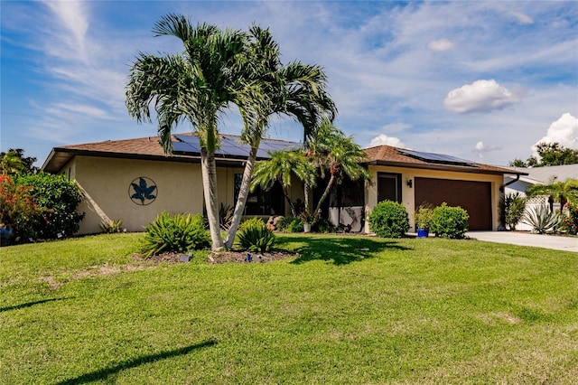 single story home with a garage, a front yard, and solar panels