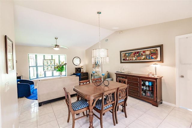 tiled dining space with lofted ceiling and ceiling fan with notable chandelier