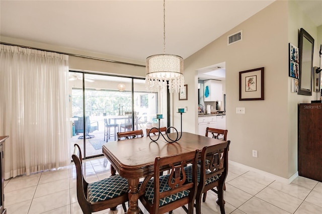 tiled dining room with lofted ceiling and an inviting chandelier