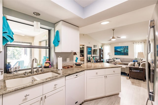 kitchen with white cabinets, vaulted ceiling, white dishwasher, and ceiling fan