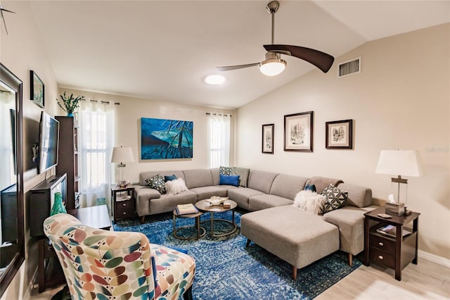 living room with lofted ceiling, ceiling fan, and light wood-type flooring