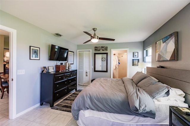 tiled bedroom with ceiling fan and a closet