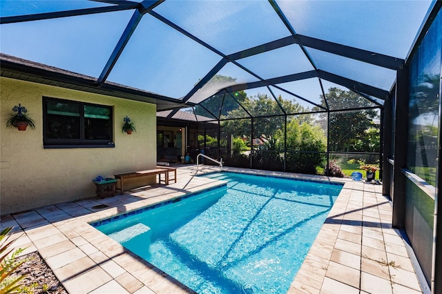 view of swimming pool with a patio area and glass enclosure