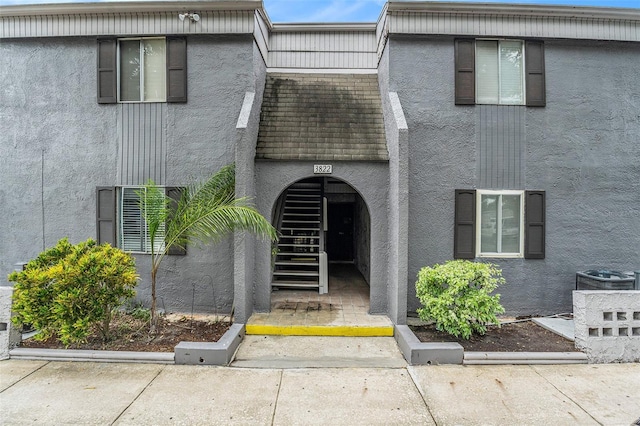 3822 Cortez Dr Unit D, Tampa, FL 33614 - view of front of home with stucco siding, mansard roof, and roof with shingles