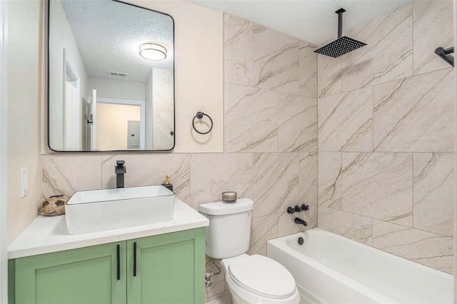 3822 Cortez Dr Unit D, Tampa, FL 33614 - bathroom with a textured ceiling, vanity, toilet, a combined bath / shower with rainfall shower, and tile walls