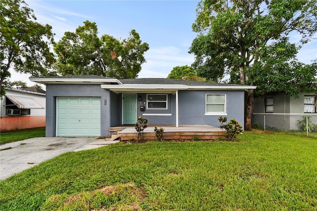 single story home featuring an attached garage, fence, driveway, stucco siding, and a front lawn