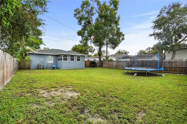 view of yard featuring a fenced backyard and a trampoline