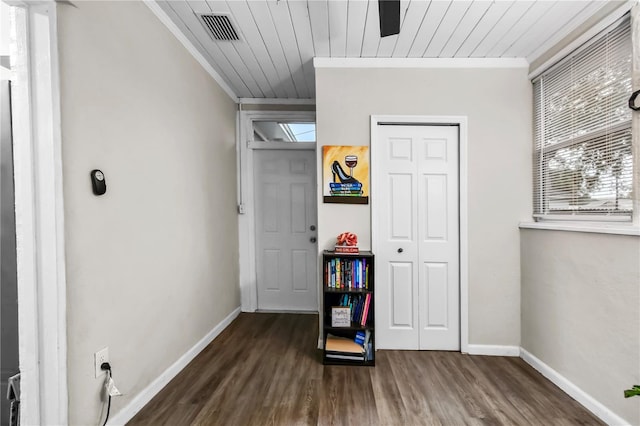 interior space featuring wooden ceiling, a closet, ornamental molding, and dark hardwood / wood-style floors