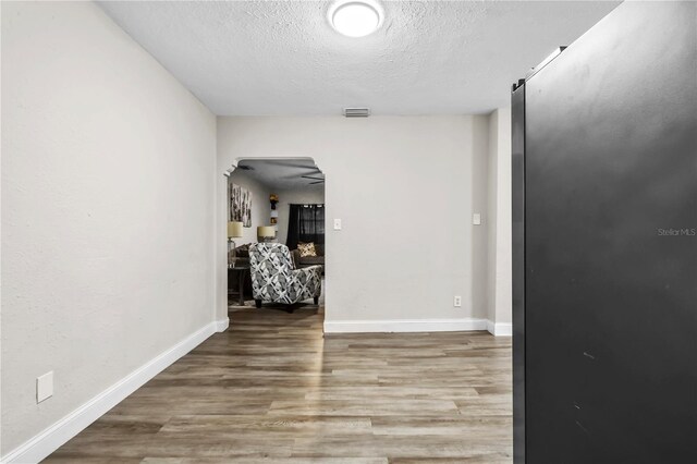 hall featuring a textured ceiling and hardwood / wood-style flooring