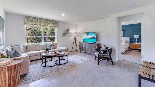 living room with a textured ceiling and light tile patterned floors